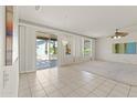 Bright living room with tile flooring, carpeted area, a ceiling fan, and sliding door access to the outdoor patio at 23114 N 146Th Dr, Sun City West, AZ 85375