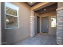 Covered front entryway with a welcome mat and decorative stone accents at 23448 N 76Th Pl, Scottsdale, AZ 85255