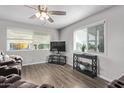 Living room with brown leather recliners, TV, and wood-look floors at 2650 W Union Hills Dr # 108, Phoenix, AZ 85027