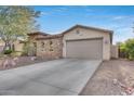 Front view of a house with a large two car garage and stone accents at 29762 N 69Th Ln, Peoria, AZ 85383