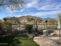 Landscaped backyard with fire pit, patio, and mountain views at 3652 N Sonoran Hts, Mesa, AZ 85207