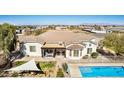 Aerial view of a home with a covered patio, lush green grass, and a sparkling blue pool at 3791 E Vista Grande Dr, San Tan Valley, AZ 85140