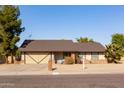 Brick ranch house with a two-car garage and mature landscaping at 3910 W Michigan Ave, Glendale, AZ 85308