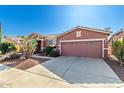 Front view of a one-story house with a two-car garage and drought-tolerant landscaping at 42621 W Heavenly Pl, Maricopa, AZ 85138