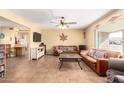 Cozy living room with tiled floor, ceiling fan, leather sofa, and view of adjoining spaces at 6058 E El Paso St, Mesa, AZ 85205