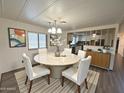 Bright dining room with round table, white chairs, and view into the kitchen, creating an inviting and open space at 8103 E Southern Ave # 84, Mesa, AZ 85209