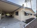 Tan mobile home with carport and palm trees in the background at 8103 E Southern Ave # 84, Mesa, AZ 85209