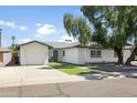 Inviting curb appeal with a well-maintained lawn and a cozy two-car garage at 8312 E Mackenzie Dr, Scottsdale, AZ 85251