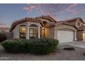 Tan house with a white garage door, showcasing the front yard at 9765 W Pontiac Dr, Peoria, AZ 85382