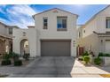 Two-story home featuring a two car garage, beautiful landscaping, and an arched entryway at 10029 E Tahoe Ave, Mesa, AZ 85212