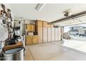 Well-organized garage with ample storage cabinets and epoxy flooring, leading to the outdoors at 10282 E Trailhead Ct, Gold Canyon, AZ 85118