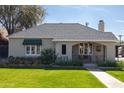 Inviting single-story home with a green awning over the front window and a well-maintained lawn at 305 W Lewis Ave, Phoenix, AZ 85003
