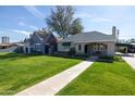 Lovely front yard with a lush green lawn and mature tree providing shade to the home at 305 W Lewis Ave, Phoenix, AZ 85003