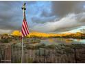 Scenic lake view with American flag and mountain backdrop at 41717 N Moss Springs Ct, Anthem, AZ 85086