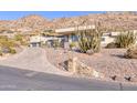 Modern home with desert landscaping, a circular driveway, and a mountain backdrop, exuding luxury and privacy at 5826 E Indian Bend Rd, Paradise Valley, AZ 85253