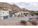 Stunning exterior of home featuring desert landscaping, a spacious driveway, and a mountain backdrop at 5826 E Indian Bend Rd, Paradise Valley, AZ 85253