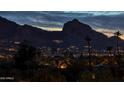 Scenic night view of twinkling city lights and a silhouetted mountain range, perfect for evening ambiance at 5826 E Indian Bend Rd, Paradise Valley, AZ 85253