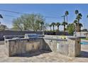 View of an outdoor kitchen with stainless steel appliances, stone surround and ample counter space in the backyard at 811 W Northern Ave, Phoenix, AZ 85021