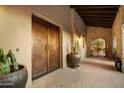 Covered entrance with beautiful stone work and double wooden doors offers exceptional curb appeal at 8260 E Sunset View Dr, Gold Canyon, AZ 85118