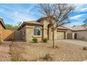 Single-story home featuring a desert landscaped front yard with mature tree at 11810 W Belmont Dr, Avondale, AZ 85323