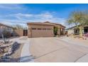 Front view of a house with a two-car garage and nicely landscaped yard at 17581 W Canyon Ln, Goodyear, AZ 85338