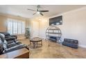 Living room featuring a large TV, comfy seating, and a circular shelving unit at 17581 W Canyon Ln, Goodyear, AZ 85338