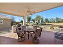 Covered patio features a stone bar area, seating, and views of the desert landscape and a community golf course at 17906 N Encanto Dr, Surprise, AZ 85374