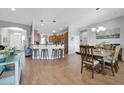 Open dining area with a wood table, seating for six, and a breakfast bar overlooking the kitchen at 22717 W Sierra Ridge Way, Wittmann, AZ 85361