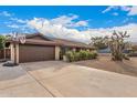 Single story home with brown brick, matching roof, and a two-car garage with a basketball hoop at 2401 E Christy Dr, Phoenix, AZ 85028