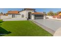 House exterior with a two-car garage and artificial turf at 3450 N 67Th Dr, Phoenix, AZ 85033