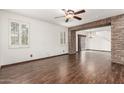 Inviting living room with wood-look floors, ceiling fan, and ample natural light at 3883 E Santa Fe Ln, Gilbert, AZ 85297