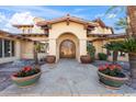 Inviting entrance with a decorative wood door and beautiful desert landscaping at 4245 E Claremont Ave, Paradise Valley, AZ 85253