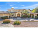 Charming exterior features a tile roof, arched entry and manicured landscaping at 4245 E Claremont Ave, Paradise Valley, AZ 85253