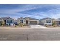 Inviting single-story home with desert landscaping, complemented by a wide driveway and blue skies at 5267 E Diatomite Dr, San Tan Valley, AZ 85143