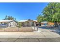 Tan single story home with a spacious yard and mature tree at 7201 W Alvarado Rd, Phoenix, AZ 85035