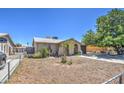 Tan single story home with a spacious yard and mature tree at 7201 W Alvarado Rd, Phoenix, AZ 85035