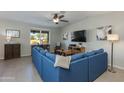 Comfortable living room features a large blue sectional sofa and a ceiling fan at 852 E Gary Ln, Phoenix, AZ 85042