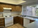 Functional kitchen with wood cabinets, white appliances, and natural light at 1550 N Stapley Dr # 35, Mesa, AZ 85203