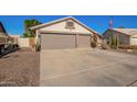 Single-story home boasting a desert landscape, a two-car garage, and an American flag at 18014 N 63Rd Ln, Glendale, AZ 85308