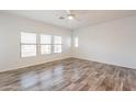 A spacious bedroom with wood-look floors, white walls, and natural light from multiple windows at 19700 N 76Th St # 2072, Scottsdale, AZ 85255