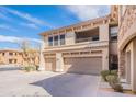 A view of the home's exterior showcasing a two-car garage, balcony, and neutral color scheme at 19700 N 76Th St # 2072, Scottsdale, AZ 85255