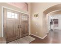 Inviting foyer with beautiful wood flooring, arched doorway, and decorative details at 22415 N 34Th Ln, Phoenix, AZ 85027