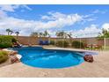 Backyard oasis boasting a stunning pool with custom rock features and a tranquil outdoor lounge area at 22415 N 34Th Ln, Phoenix, AZ 85027