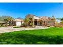 Beautiful front exterior showcasing lush landscaping and large circular driveway at 22477 S 197Th Cir, Queen Creek, AZ 85142