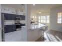 Modern kitchen with dark cabinets, white quartz countertops, and island at 22488 N Mulligan Dr, Maricopa, AZ 85138