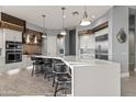 Modern kitchen with white cabinets, stainless steel appliances, and breakfast bar at 23238 N 94Th Pl, Scottsdale, AZ 85255