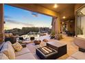 Relaxing covered patio with fire pit, comfortable seating, and pool views at 23238 N 94Th Pl, Scottsdale, AZ 85255