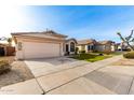 View of a beige house and neighborhood with green lawns and clear sky at 3037 E Roveen Ave, Phoenix, AZ 85032