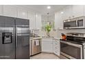Well-lit kitchen featuring stainless steel appliances, white cabinetry, and a corner sink with a window view at 3132 N 15Th Ave, Phoenix, AZ 85015