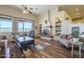 Inviting living room featuring a decorative fireplace, wood floors, and large windows for natural light at 4185 S Redtail Trl, Gold Canyon, AZ 85118